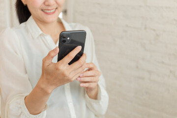 using cell phone hand holding mobile texting message contact us.chatting,search internet information in office.technology device communication connecting