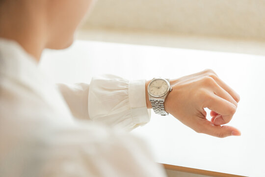 fashionable wearing stylish looking at luxury watch on hand check the time at workplace.concept for managing time organization working,punctuality,appointment