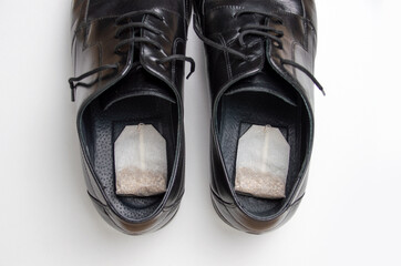 High angle shot of a tea bag inside the shoes. concept of removing unpleasant odors
