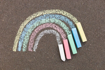 Chalk rainbow painted on the road. The concept of hope for a happy future.
