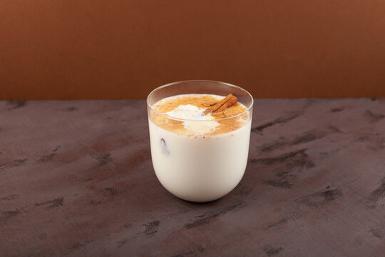Salep or Sahlab in glass on brown background. Salep - Turkish traditional winter drink. Selective focus, copy space