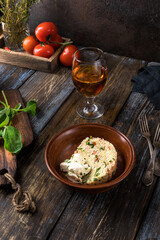 Plate of couscous with tomatoes, vegetables and feta cheese. Basil leaves, tomatoes, herbs and teapot with cup are on a wooden table. Menu for restaurant, cafe, bar. Close up.