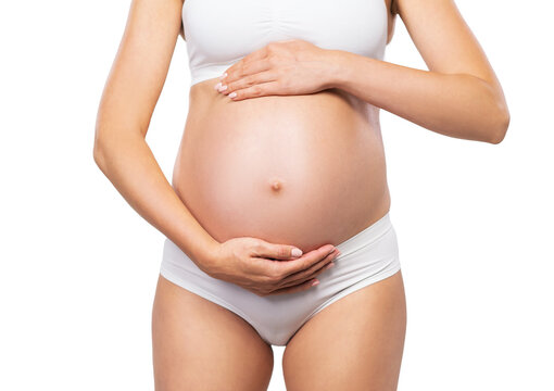 Young pregnant woman in swimsuit. Girl expecting a baby and touching her belly isolated on white background. Close-up image.
