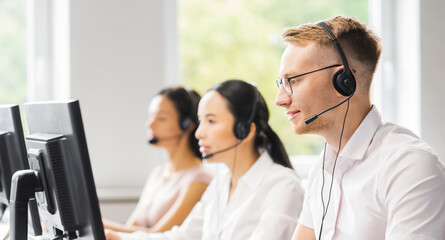 Team of professional support staff working in the office. Colleagues in the workplace solve customer problems. Call center and customer support concept. - obrazy, fototapety, plakaty