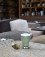 A transparent glass of matcha tea on the table