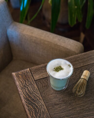 A transparent glass of matcha tea on the table