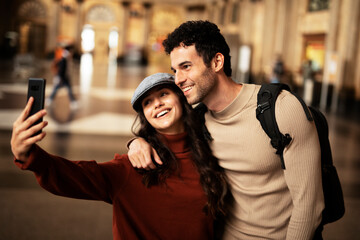 Beautiful couple at railway station waiting for the train. Young woman and man waiting to board a train..