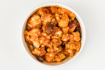 A bowl of chicken marinated in sweet chili sauce. On a white background. Top view.
