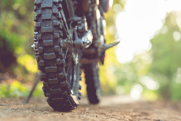 Part of a motocross wheel on a mound, with sunrise copyspace for your individual text. A part of a...