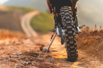 Part of a motocross wheel on a mound, with sunrise.copyspace for your individual text