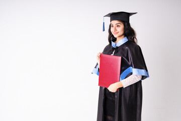 University graduate indian race woman wearing academic regalia and red diploma with copy space.
