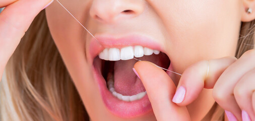 Oral hygiene and health care. Smiling women use dental floss white healthy teeth. Dental flush - woman flossing teeth. Dental floss. Taking care of teeth. Healthy teeth concept. Teeth Flossing - obrazy, fototapety, plakaty