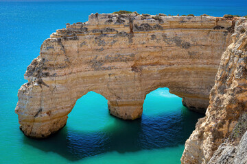 Sea arch and turquoise water of Atlantic Ocean in Praia da Marinha beach in Algarve, Portugal.