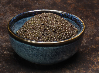 A small bowl of black lumpfish roe, a cheap caviar alternative