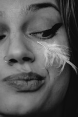 Vertical aesthetic portrait of a Caucasian female with messy hair and feathers