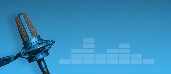 Podcast background. Recording studio microphone with audio meter on blue background with copy space...