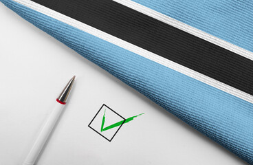 Pencil, Flag of Botswana and check mark on paper sheet 