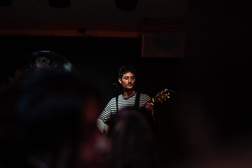 Fototapeta na wymiar Musician playing guitar during a concert