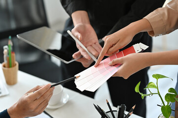 Close up designers or a creative workers working together in the office and pointing to a color palette, for art, design, technology and business concept.