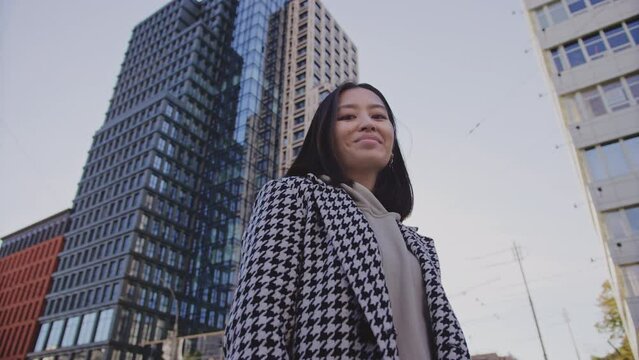 Portrait of a businesswoman under a highrise building in city