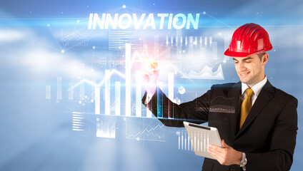 Young businessman with helmet drawing on virutal screen