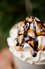 Delicious coffee drink with cream and pieces of caramel and chocolate.