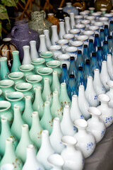 Various neat ceramic colored vases for sale at flower market