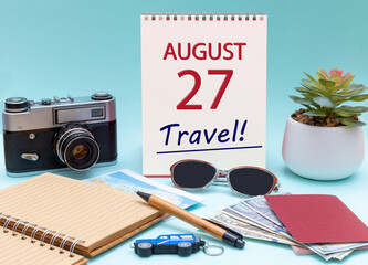 Travel planning, vacation trip - Calendar with the date 27 August glasses notepad pen camera cash passports.