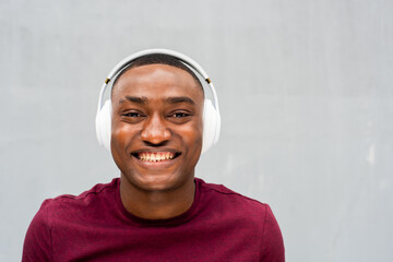 front portrait smiling African american man with headphone against gray background