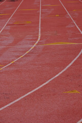 Fototapeta premium The red pavement and the starting grid for runners on a High School track