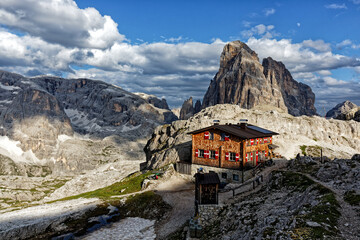 Peaks of the Sexten Dolomites with a mountain hut in the evening light, summer in South Tyrol,...