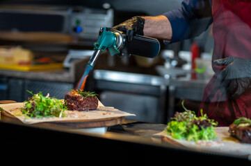 A chief-cooker cooking in the kitchen in the restaurant