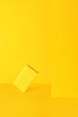 Dishwashing sponge on yellow, minimalism, monochrome.