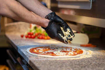 Chef baking pizza in the italian pizzeria - obrazy, fototapety, plakaty