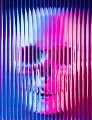 Neon illuminated human skull behind blurred glass with lines. NFT, crypto art background.