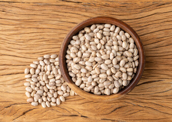 Brown beans on a bowl over wooden table