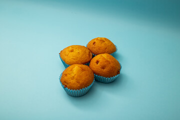 Bright cupcakes in blue packaging on a blue background