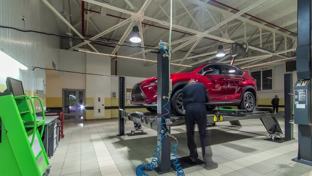 Car on stand with sensors on wheels for wheels alignment camber check in workshop of Service station timelapse.