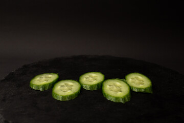 Green cucumber on black background