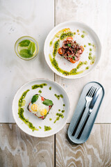 Smorrebrods, Danish open sandwich with salmon, egg, roast beef and sweet onions avocado and cilantro sauce.