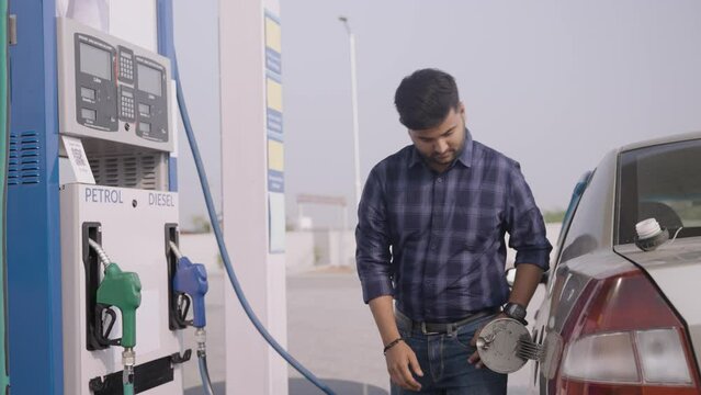 young man fueling car at petrol or gas filling station - concept of transportation, transportation and self-service.
