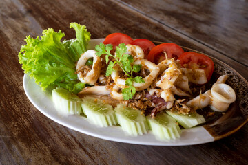 Fried squid with garlic on a wooden table