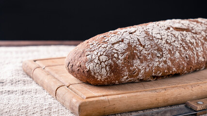 Whole carrot bread on a wooden board. Copy space
