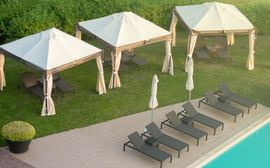 View of the pool with blue water, sun loungers and umbrellas.