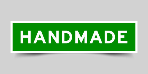 Sticker label with word handmade in green color on gray background