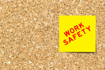 Yellow note paper with word work safety on cork board background with copy space