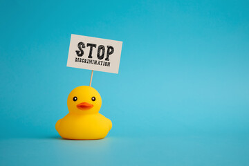 Rubber duck carries a signboard with the word stop discrimination. Political activism against...