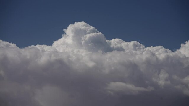 Dynamic cloudscape with huge cumulus clouds boiling and rolling across the sky - time lapse