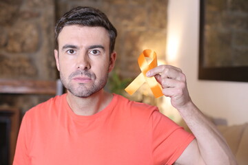 Man holding an orange ribbon