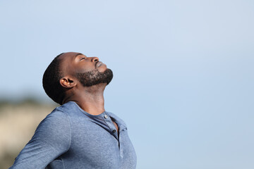 Man with black skin breathing fresh air standing in nature